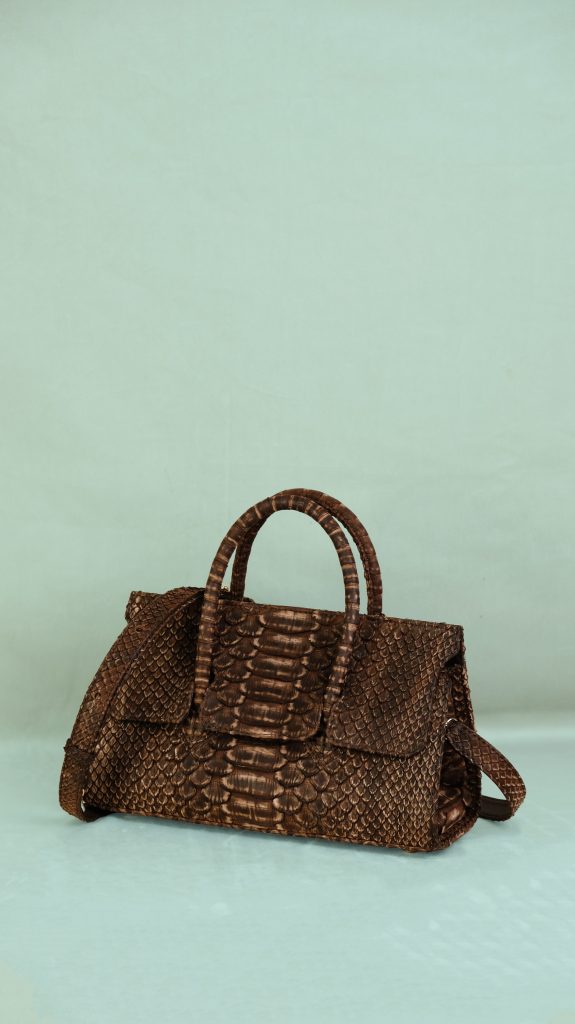 KYRA Adriana Lungo structured handbag featuring expandable side wings, a discreet sunglasses compartment at the back, and a signature top handle for arm carry for Eid 2026.