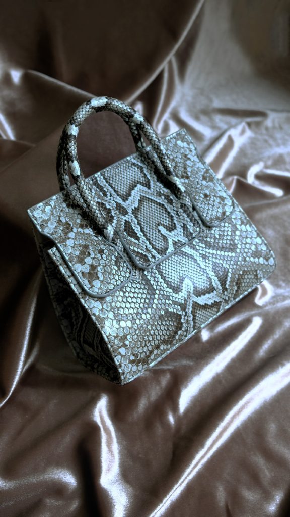 KYRA Adriana Small Natural python leather bag featuring a semiclassical design with a unique handle, glasses holder, and expandable side wings for Eid 2026.
