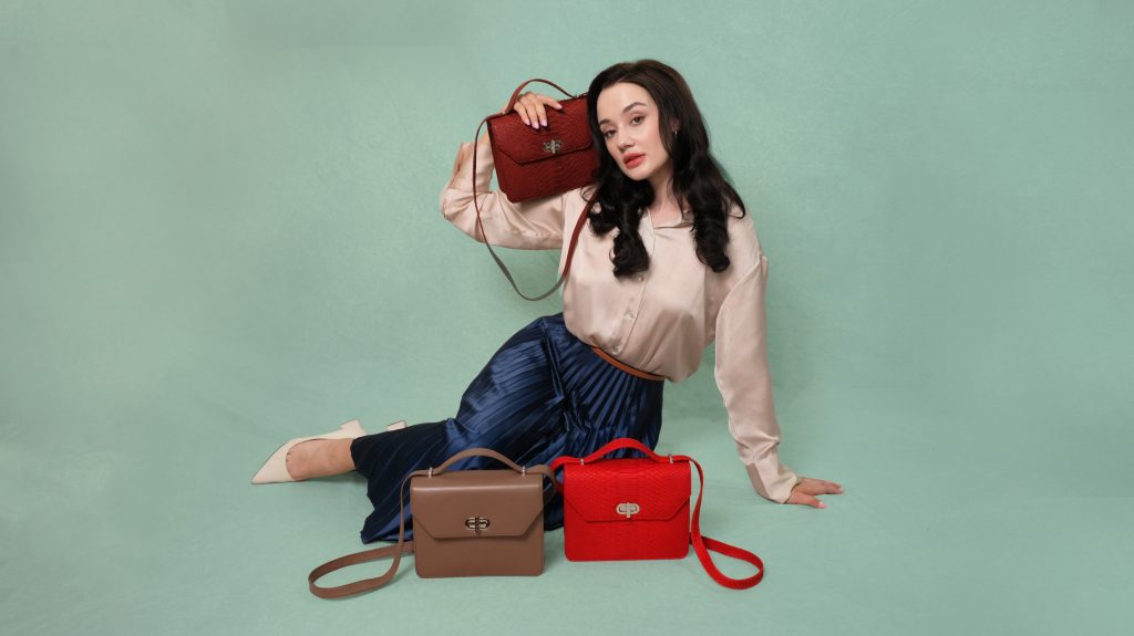 KYRA Cosette Rum Raisin exotic python leather handbag featuring an adjustable top handle, structured compact design, and suede lining for Eid 2026.