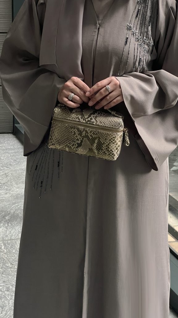 KYRA Picco 19 multifunctional bag in genuine python leather, sleek minimalist design, convertible from sling to clutch, luxury gold hardware for Eid 2026.