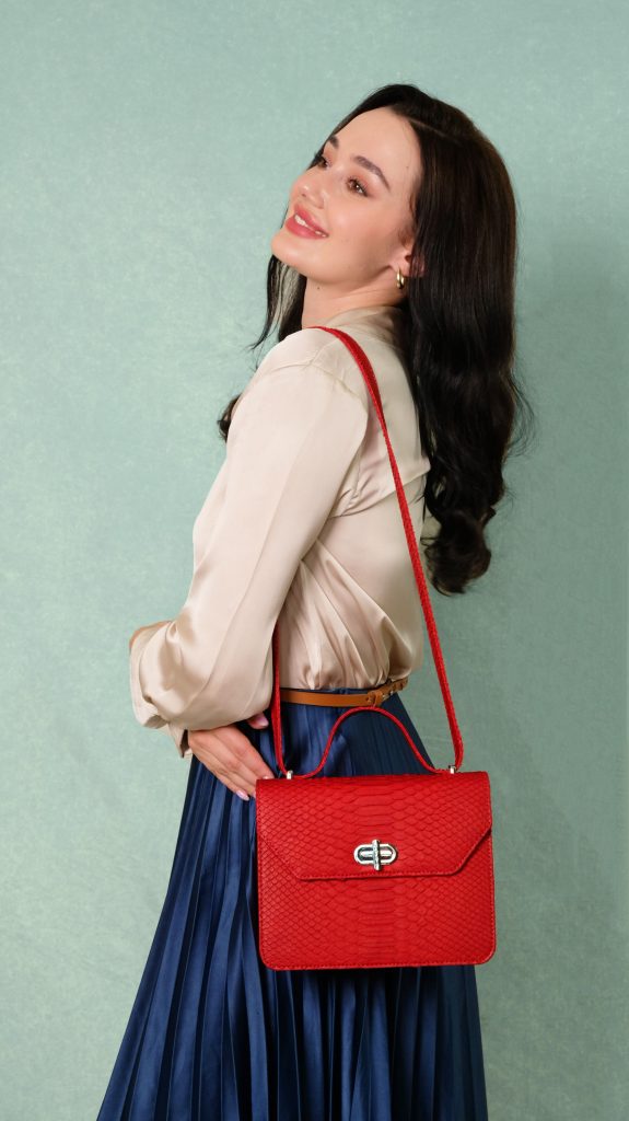 KYRA Cosette Rum Raisin exotic python leather handbag featuring an adjustable top handle, structured compact design, and suede lining for Eid 2026.