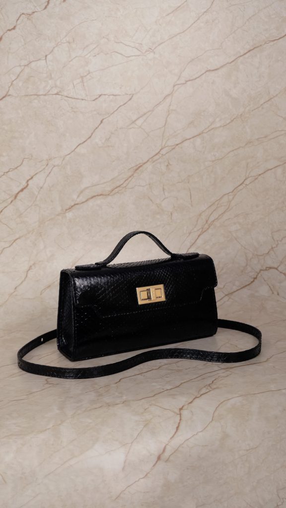 KYRA Luna 25 structured black python leather handbag featuring a 3-in-1 luxury design (top-handle, clutch, and shoulder bag) with signature gold hardware for Eid 2026.
