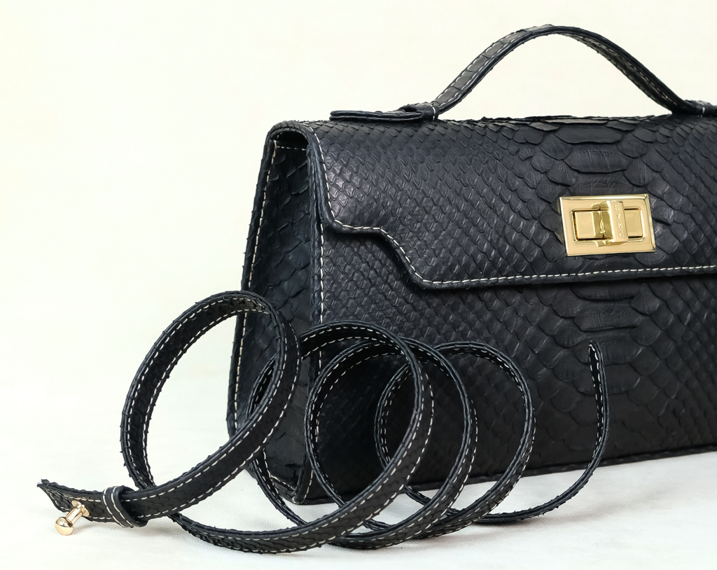 Close-up of precision contrast stitching on a handcrafted KYRA exotic leather bag showing high-quality raw materials