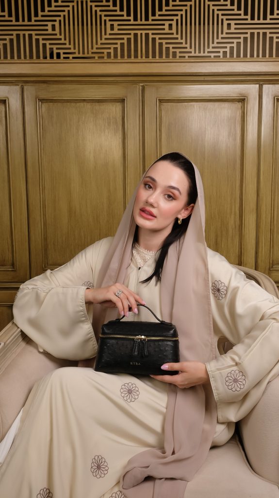 KYRA Picco Black Ostrich leather handbag featuring a minimalist silhouette with signature gold hardware and a convertible 3-in-1 strap design for timeless luxury.