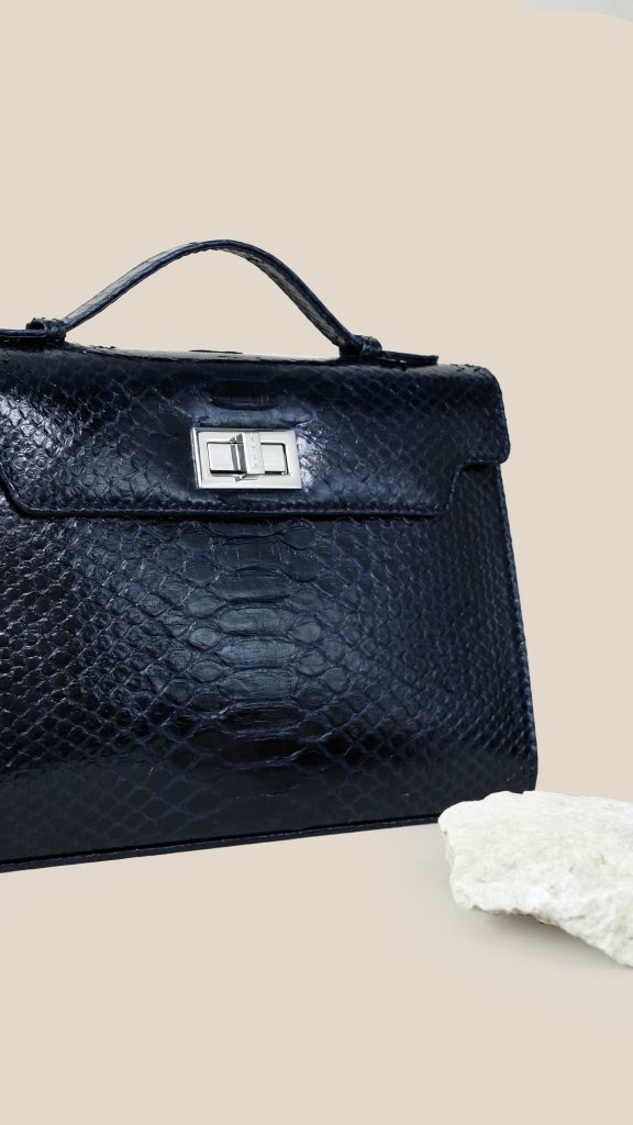 Luna 29 Medio exotic python leather bag with signature Kyra lock and top handle in a structured silhouette