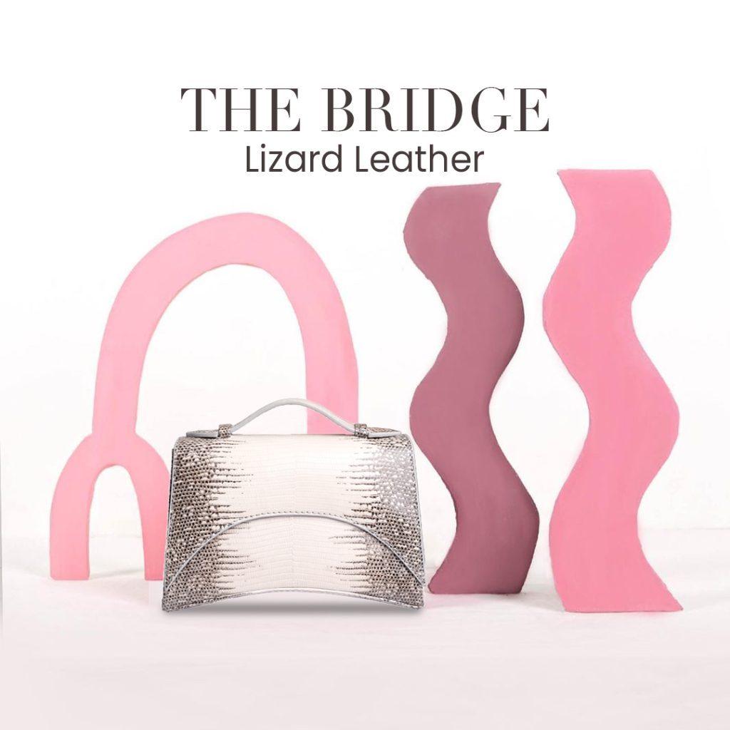 KYRA The Bridge natural lizard leather top-handle bag in ivory and grey, structured silhouette with silver hardware.